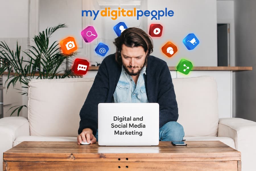 Man using a laptop displaying social media icons, illustrating the difference between digital and social media marketing