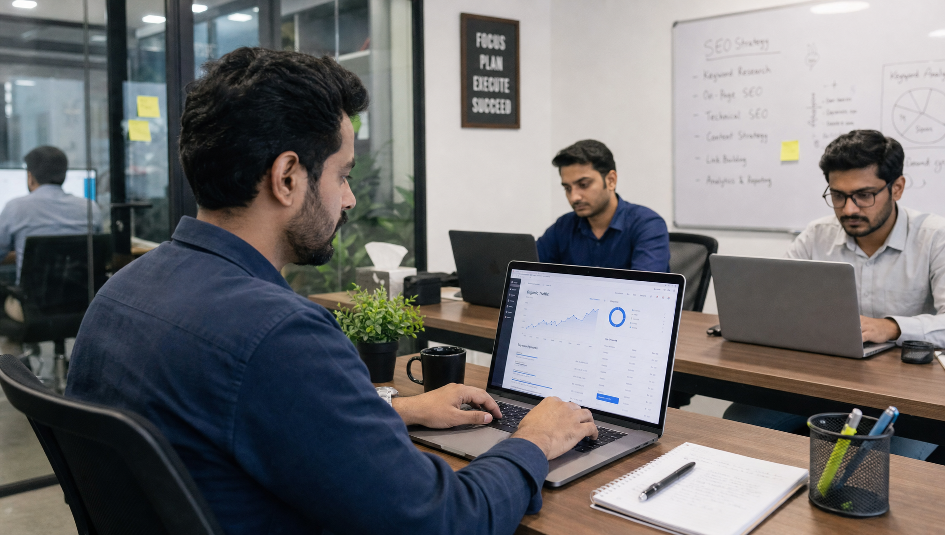 SEO team working in a modern Pakistani office with analytics dashboards and an SEO strategy board.